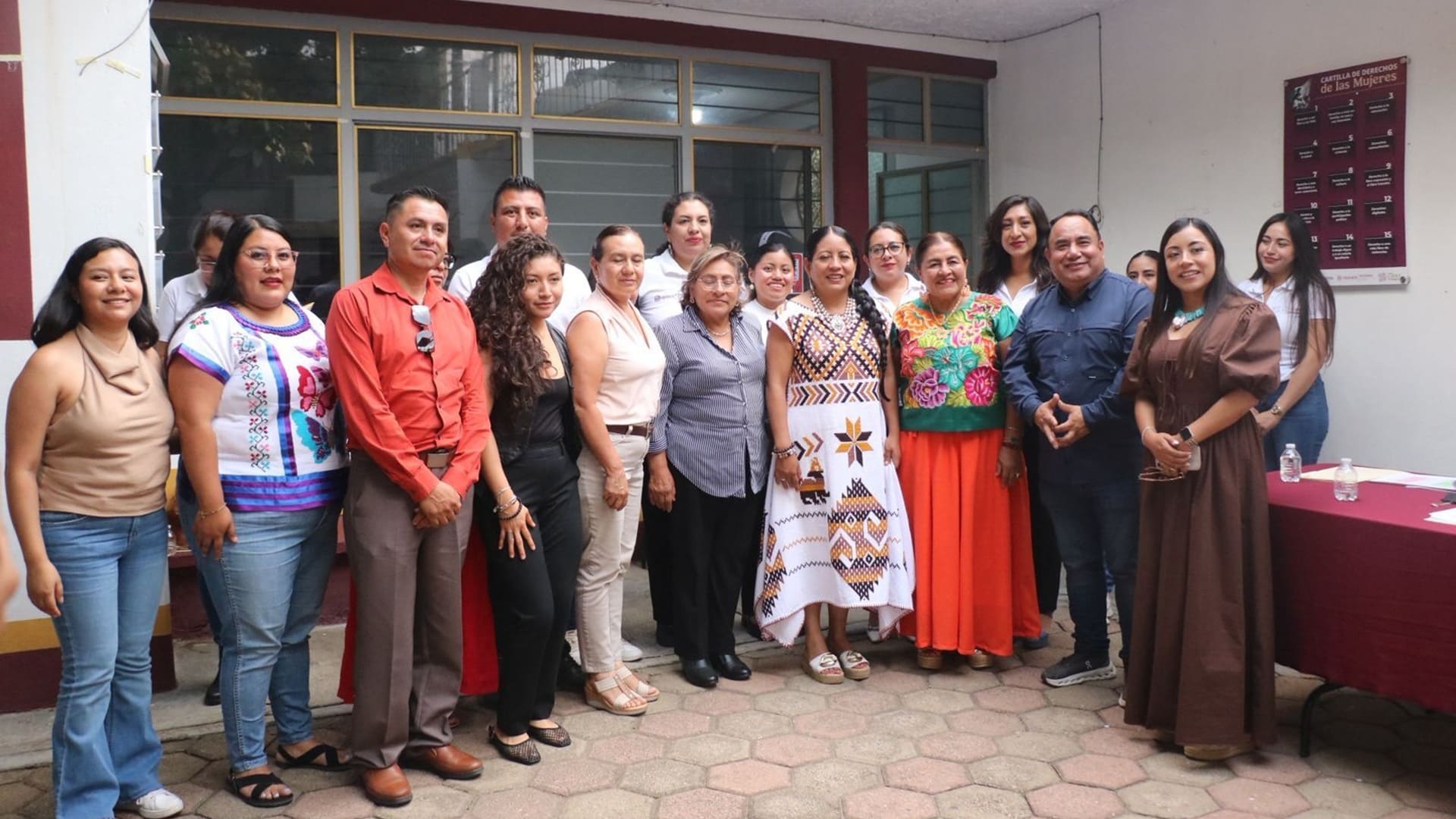 Varias mujeres y algunos hombres de pie y mirando a la cámara para ser retratados.
