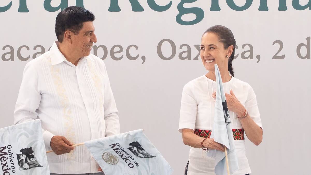 Salomón Jara y Claudia Sheinbaum con banderas en las manos y sonrientes