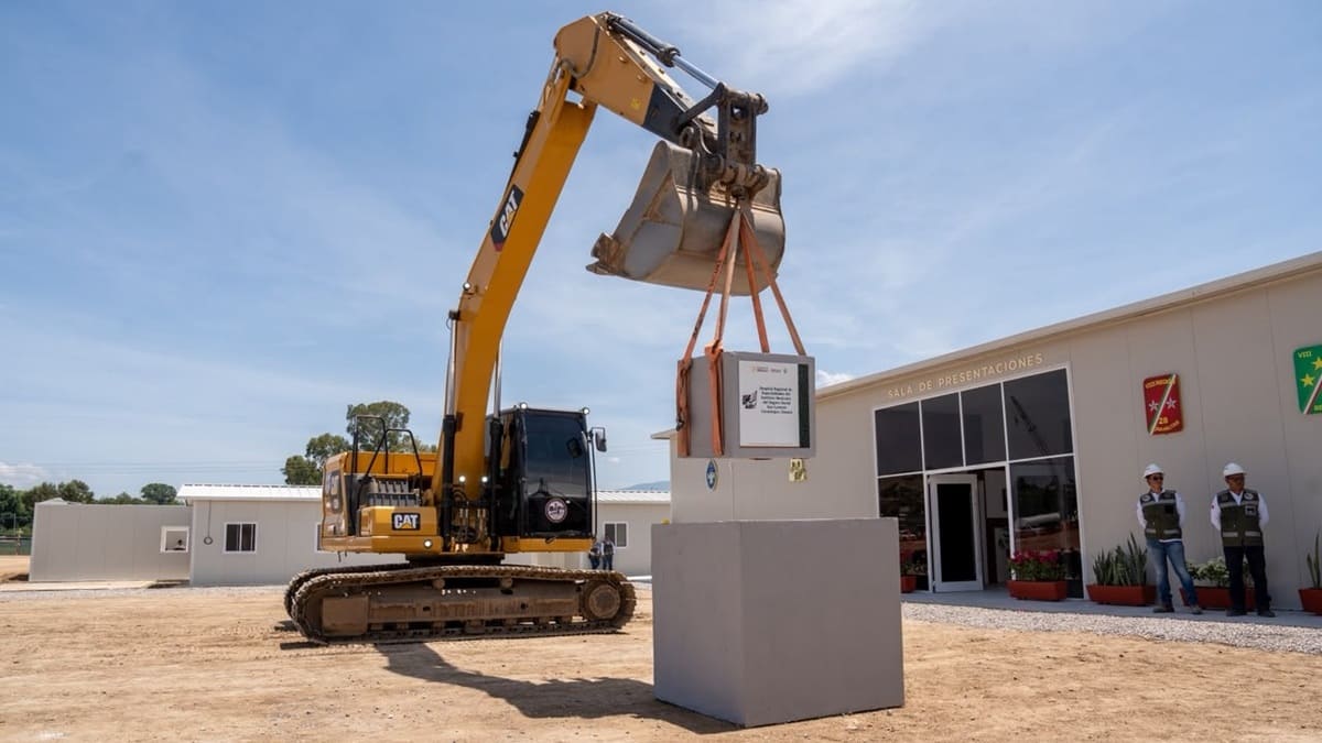 Maquinaria pesada laborando en junto a un edificio de grandes dimensiones