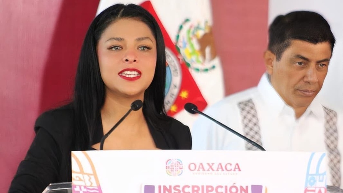 Fernanda Chávez con saco negro, junto al gobernador Salomón Jara Cruz en una conferencia de prensa