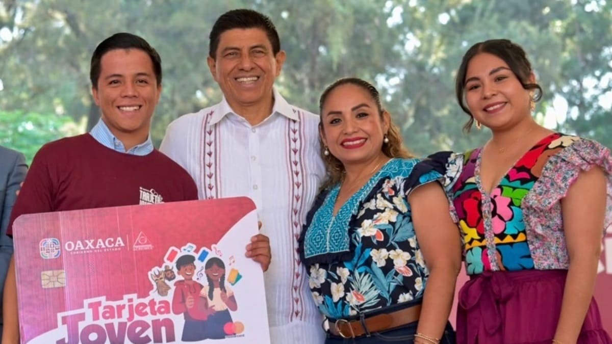 Salomón Jara, con camisa blanca, junto a jóvenes que recibieron una Tarjeta Joven simbólica de gran tamaño