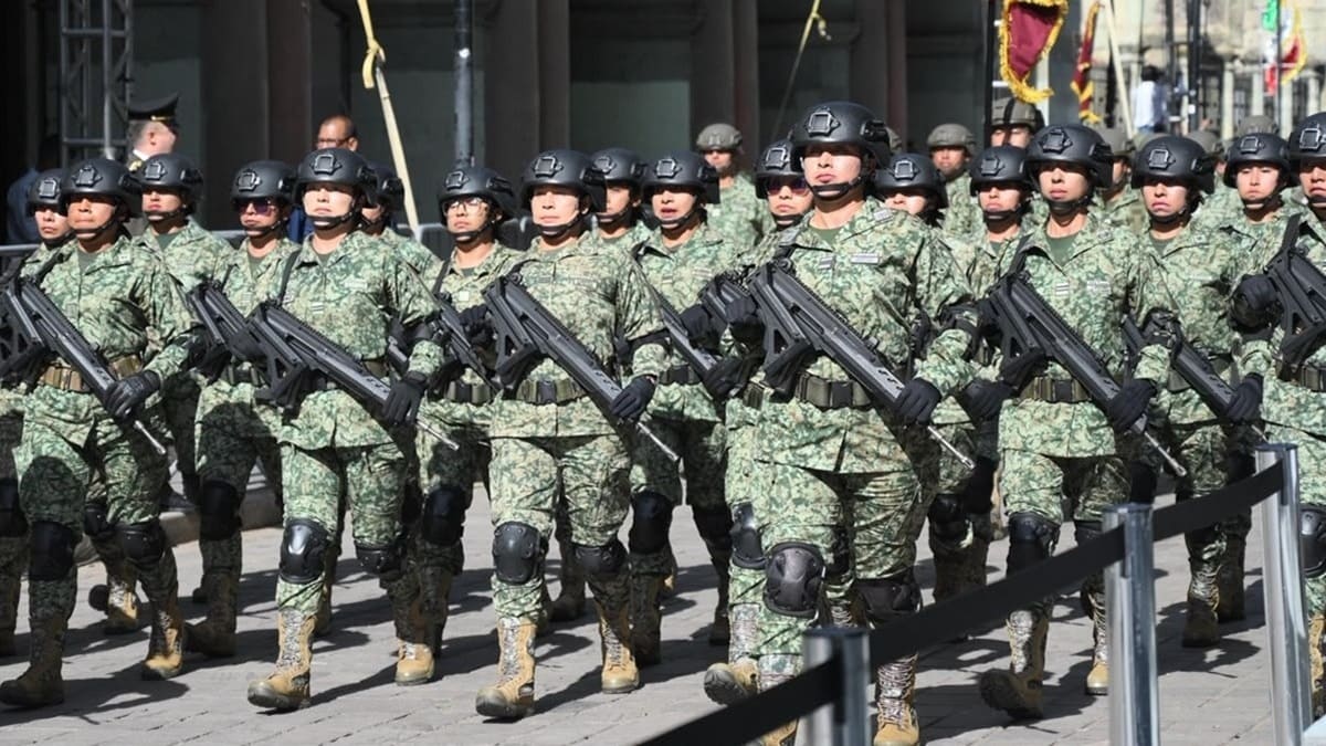Elementos militares con uniforme verde y armas largas avanza por una calle en Oaxaca