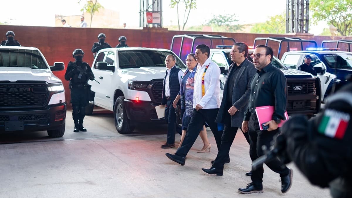 Salomón Jara y otros funcionarios caminan entre vehículos negros de seguridad pública