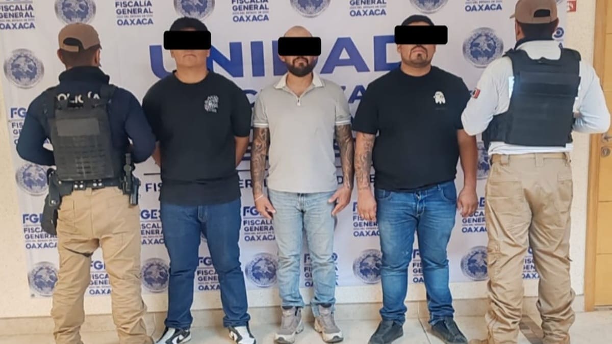 Tres hombres jóvenes detenidos con los ojos protegidos por mandato de ley y custodiados por elementos de seguridad