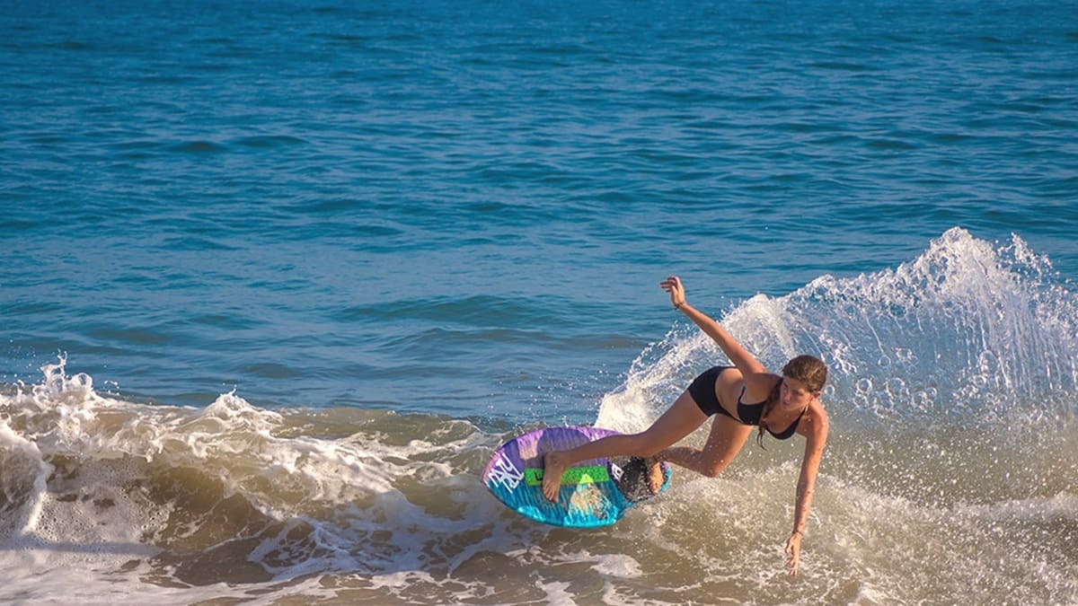 Mujer en bikini surfeando en la playa principal de Mazunte, Oaxaca