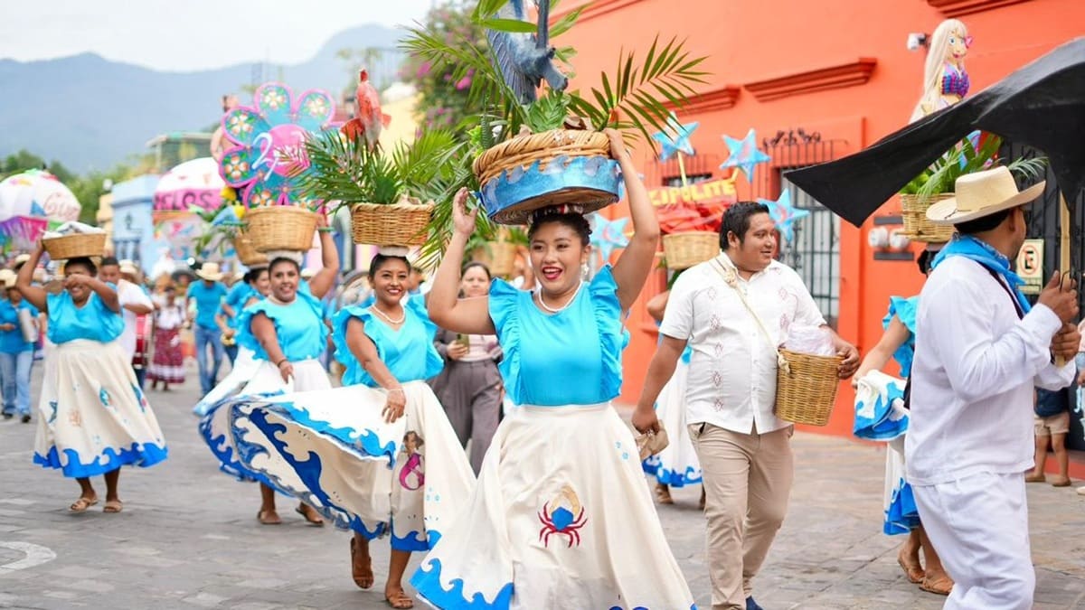 Danzantes oaxaqueñas con trajes regionales sobre una calle