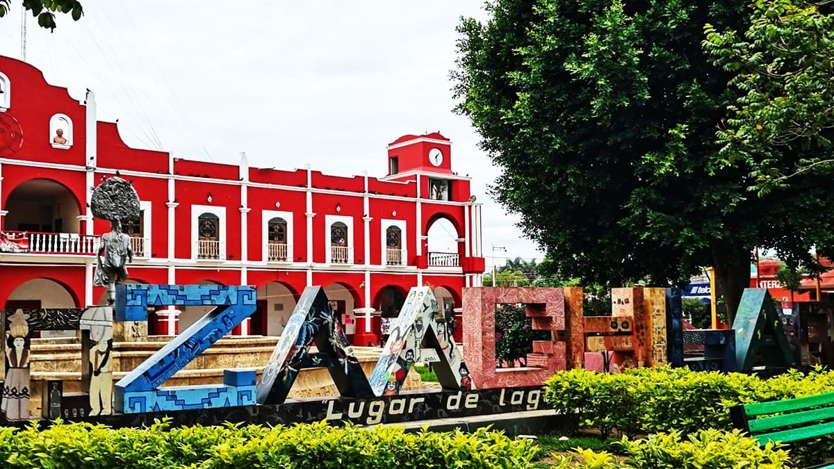 Vista parcial de la plaza central de Zaachila, donde se aprecia su Palacio Municipal con fachada roja y con jardines