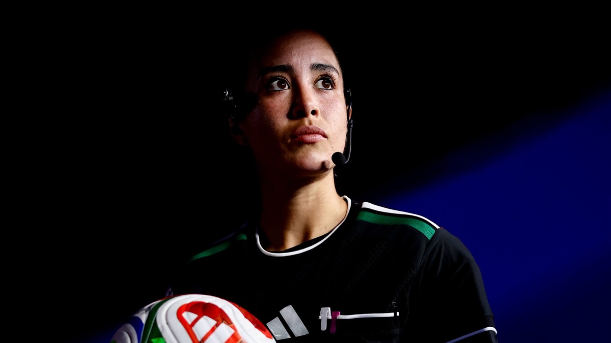 Katia Itzel García sosteniendo una pelota en un cuarto con poca iluminación