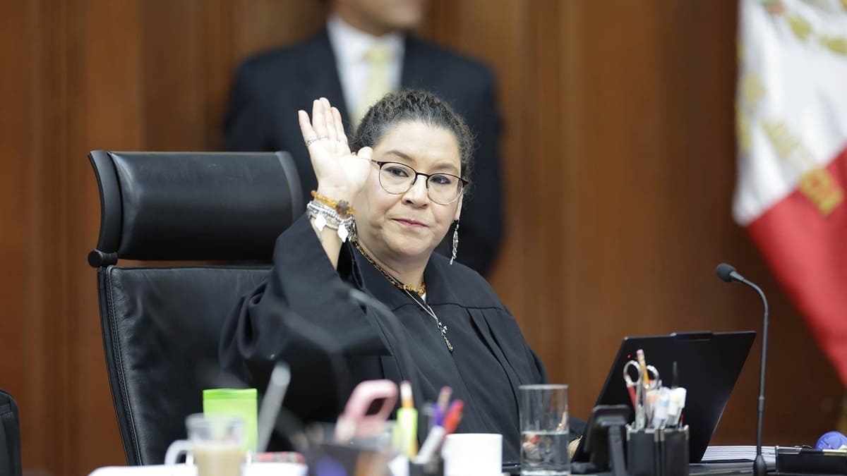 La ministra Lenia Batres, con toga negra, levantando la mano sentada