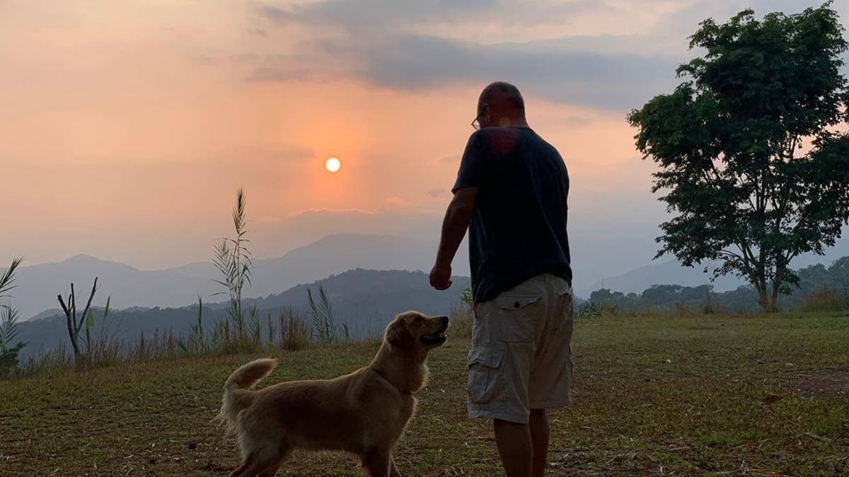 Imagen del periodista Alejandro Leyva en un atardecer junto a un perro