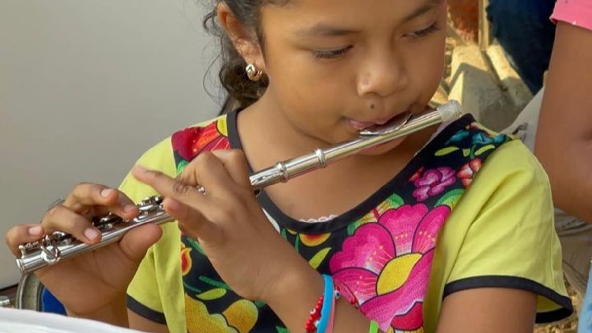 Pequeña niña tocando un piccolo