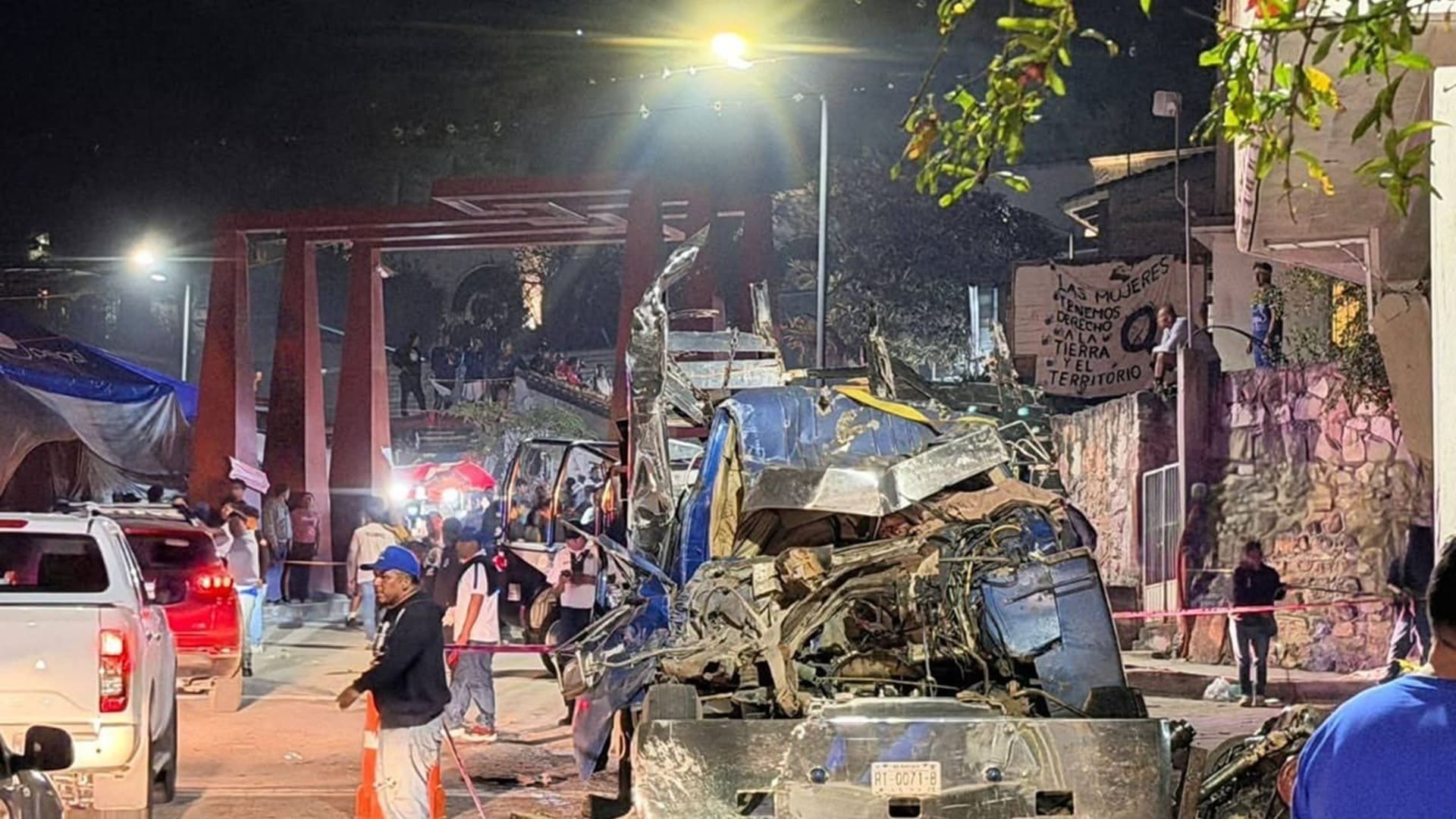 Una persona junto a un camión chocado y varios escombros.