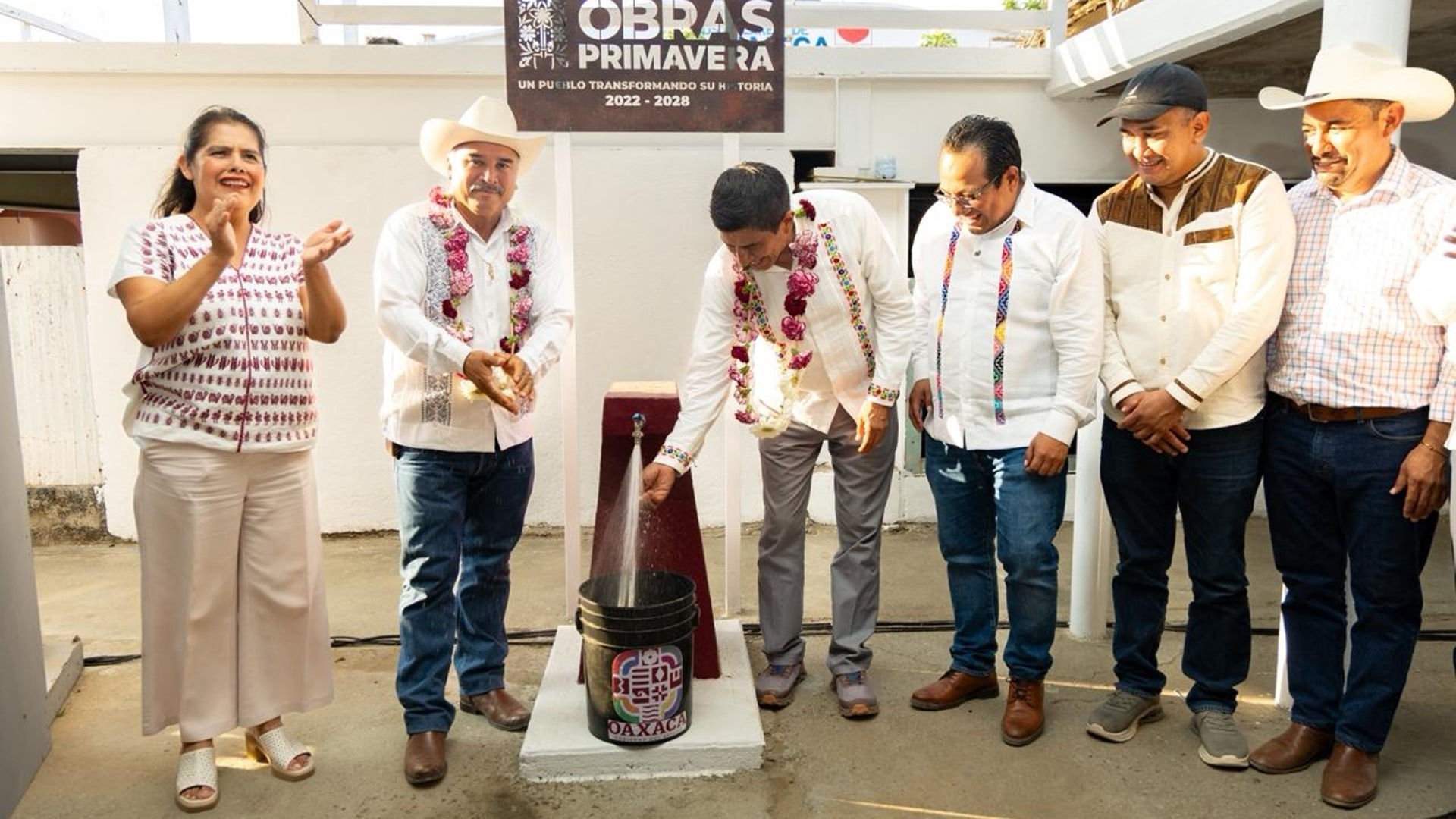 Rodeado de varias personas, Salomón Jara abre una llave de la que sale agua.