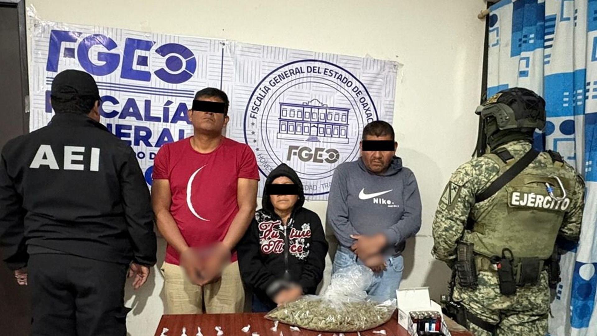 Dos hombres y una mujer, los detenidos en Tlacolula, visten de forma casual y tiene el rostro cubierto; están de pie entre un soldado y un agente de investigación.
