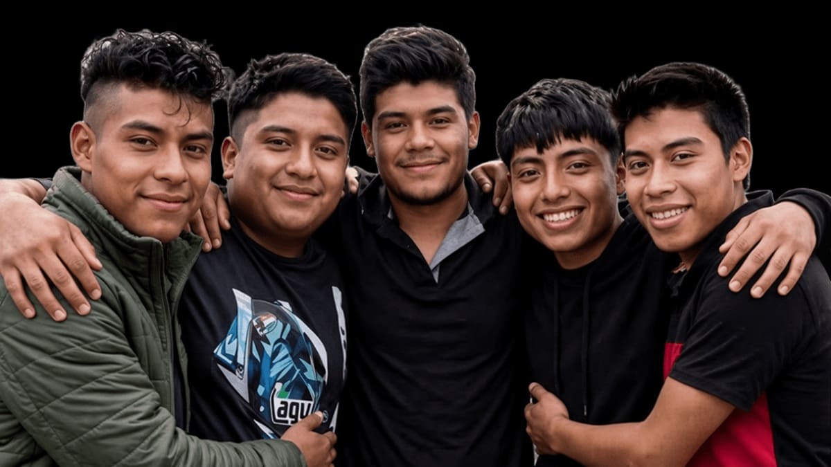 Cinco jóvenes con ropa informal y casual formados y abrazados para tomarse la foto