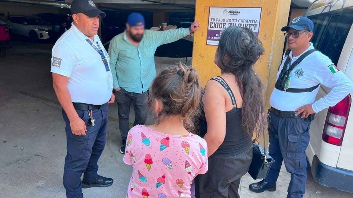 Cuatro adultos y una niña en una conversación junto a un auto