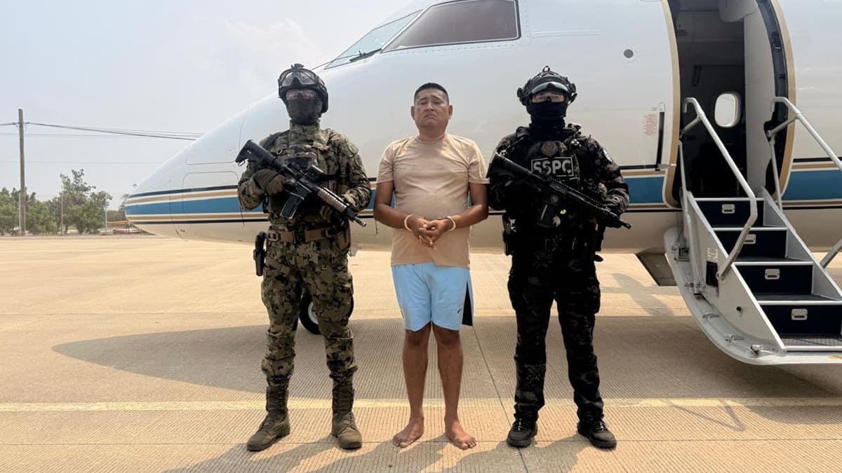 Carlos Alberto, alías La Parka, en shorts y esposado de manos entre dos agentes de seguridad