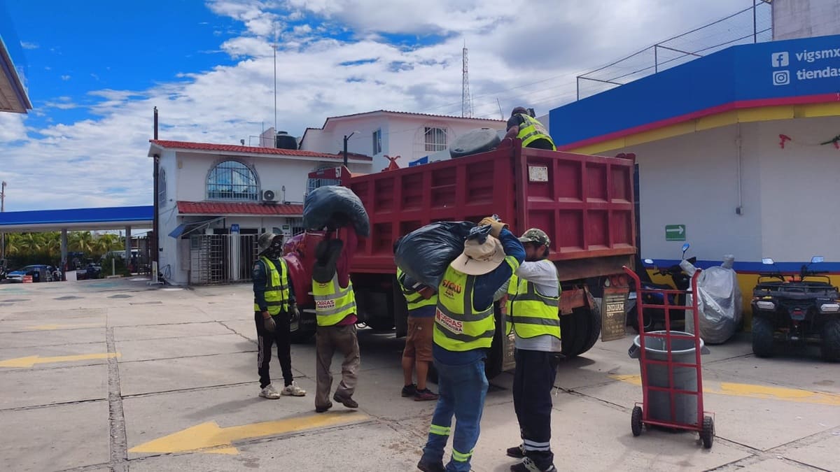 Trabajadores de limpia realizan labores con un camión en una calle de Puerto Escondido