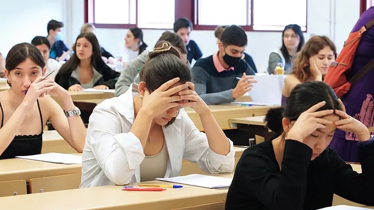 Imagen de estudiantes realizando un examen sentados en pupitres
